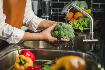 Keuken spatwand met foto Hand of maid washing tomato fresh vegetables preparation healthy food in kitchen © joyfotoliakid