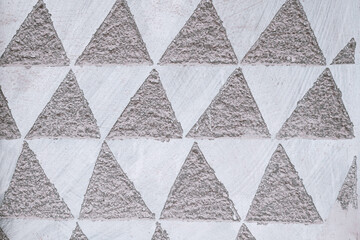 Relief pattern of triangles on stone surface, background texture