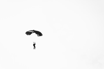 Abstract minimal picture with a parachute jumper on a white background.