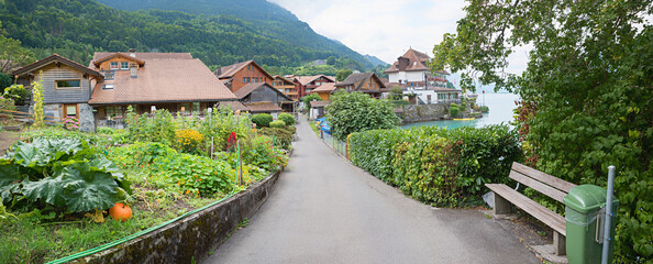 idyllic lakeside promenade tourist resort Iseltwald, panorama landscape switzerland