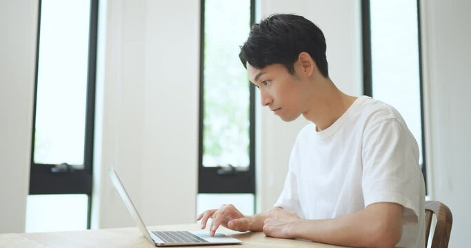 ノートパソコンを見て喜ぶ男性