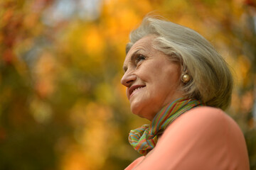 Senior woman walking in the park in autumn. 