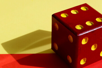 a large dice on a red and yellow background