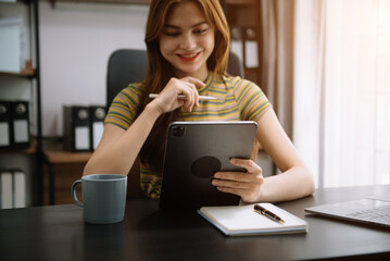 Businesswoman working in the office with working notepad, tablet and laptop documents .