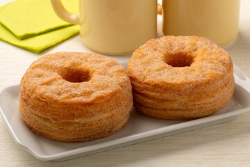 Plate with a pair of tasty sweet cinnamon Cronuts close up