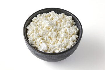 White grainy curd cheese in a gray ceramic bowl. Cottage cheese in a cup isolated on white background