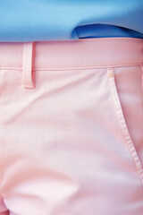Close-up of fashion details of trendy jeans in pastel delicate color. Texture of denim fabric, fragment of fashionable pants of pastel pink color.