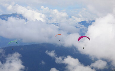 some paragliders even have two people flying at the same time in the clouds in the mountains