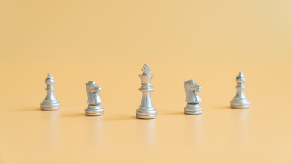 Concept of business leadership, silver color chess on the orange background and successful competition winner.
