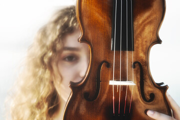 woman musician hides behind her violin, abstract concept