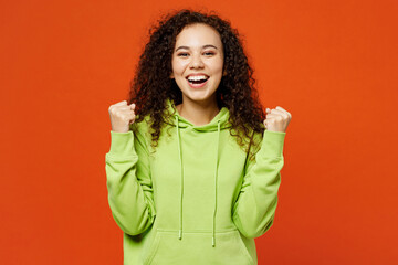 Young happy woman of African American ethnicity she wear green hoody casual clothes doing winner...