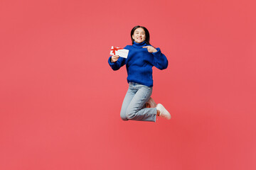 Full body young woman of Asian ethnicity wear blue sweater casual clothes jump high hold gift...