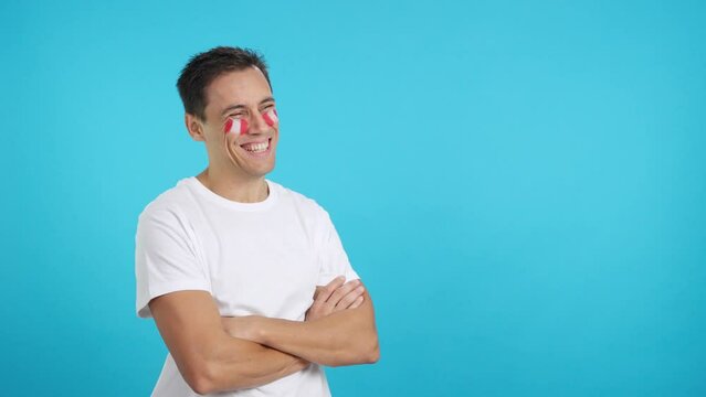 Happy man with peruvian flag painted on face looking away
