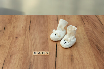 Tiny baby socks with the word baby made of wood herald the arrival of the baby to the world and the joy of the parents.
The concept of pregnancy and family, the happiness that the birth of a child wil