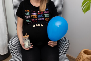 The mother of a future child holding banknotes in a jar in one hand and a balloon in the other. the concept of state welfare and saving for the child's future.