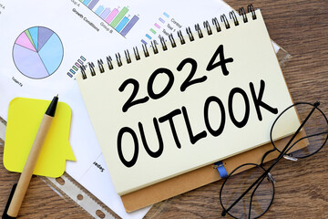 OUTLOOK 2024 office desk, financial charts. words on the page