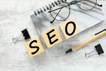 SEO wooden blocks with text. on a gray notepad near the glasses