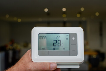Central heating thermostat control panel. Handheld device used to control the temperature in the home. Monitoring power usage helps to save on energy costs over the winter period. 