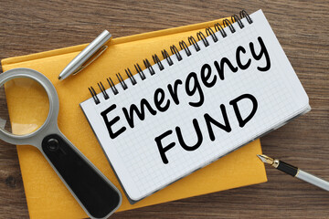 EMERGENCY FUND yellow notepad with text on the page. white pen - obrazy, fototapety, plakaty