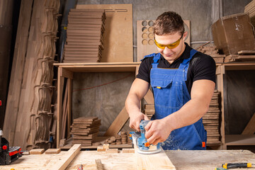 Worker grinds the wood of angular grinding machine