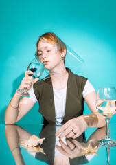 girl sitting at a table with glasses with a fish cockerel