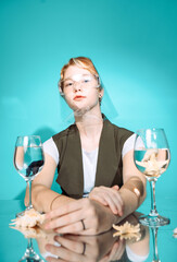 girl sitting at a table with glasses with a fish cockerel