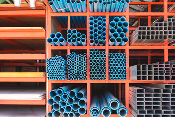 Various sizes of many blue PVC water pipes with rectangular carbon steel tubes and gypsum boards on...
