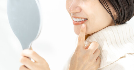 鏡で歯を確認する女性 - obrazy, fototapety, plakaty