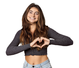 Young Caucasian woman in studio setting smiling and showing a heart shape with hands.