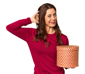 Middle-aged woman with Valentine's Day heart box in studio touching back of head, thinking and making a choice.