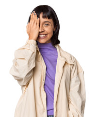 Naklejka premium Young Hispanic woman with short black hair in studio having fun covering half of face with palm.