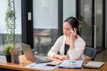 Obraz premium Businesswoman sitting in front of laptop considering office work. Think hard and take your work seriously. Stressed with assigned work.