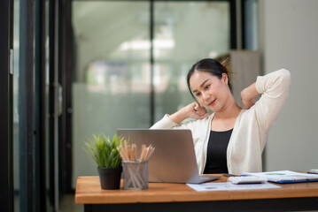 Businesswoman stretching lazy at the desk to relax while working in the office. Feeling stressed and achy from work.