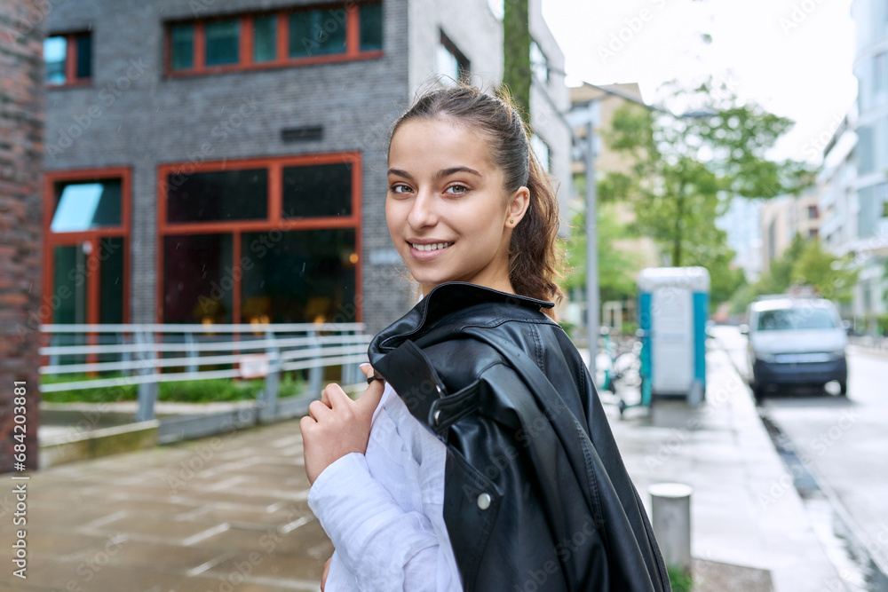 Wall mural Portrait of smiling teenage girl on street of city