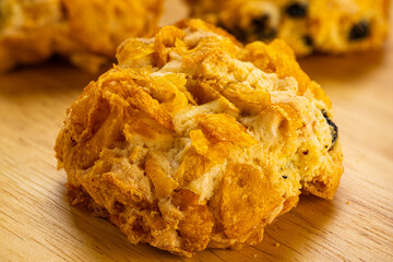 View of crunchy delicious homemade corn flakes cookies on wooden board, closeup, horizontal.