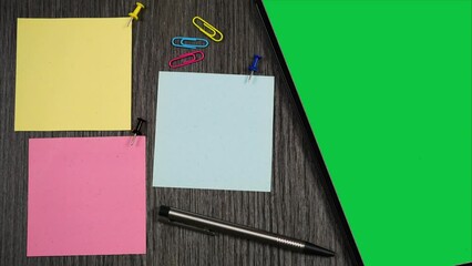 Top view office table with sticky notes and green tablet screen. Blank paper notes. Stop motion