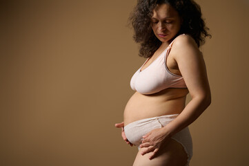 Body positive woman mother in lingerie, with postnatal naked belly with flaws stretch marks few...
