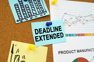 Business charts and stickers with the inscription hang on the board - DEADLINE EXTENDED
