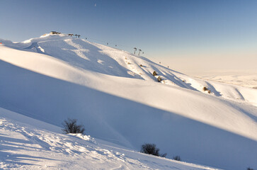 ski traces and fresh powder on the slopes of Amirsoy mountain resort (Tashkent region, Uzbekistan)