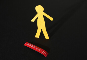 Paper cutout person with red Depression label on dark background