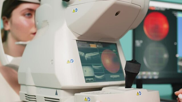 A female ophthalmologist performs a retinal examination using optical coherence tomography (OCT). The concept of medical vision diagnostics or vision correction.