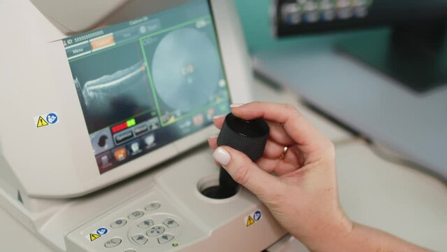 A female ophthalmologist performs a retinal examination using optical coherence tomography (OCT). The concept of medical vision diagnostics or vision correction.