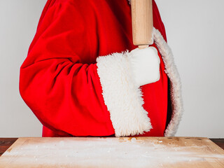 Ready to start cooking. Santa Claus in traditional costume holds a rolling pin. Cooking, holiday food concepts.