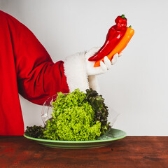 Santa Claus holds fresh red sweet paprika in his hand. Healthy eating and preparing food concepts.