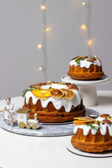 A set of three festive pies decorated with sugar icing, rosemary sprigs, and orange slices. Festive...