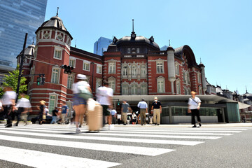 	横断する人で賑わう東京駅丸の内北口前の交差点風景 - obrazy, fototapety, plakaty