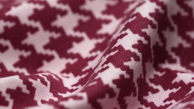 closeup of crumpled cozy fabric with pattern of houndstooth in burgundy and white. rotation of soft cotton fabric with bright pattern. macro. fabric background textile production.