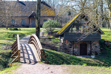 
view of a farm with a house and a wooden bridge over the river