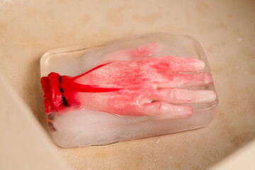 Ice-cold horror: A conceptual horror image with an artificial human hand frozen within an ice block, creating an eerie and suspenseful atmosphere