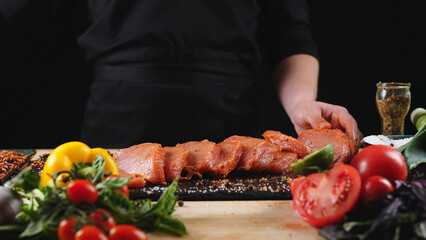 The chef cuts raw meat with a knife. Raw beef steak sliced on a wooden board. Delicious food concept